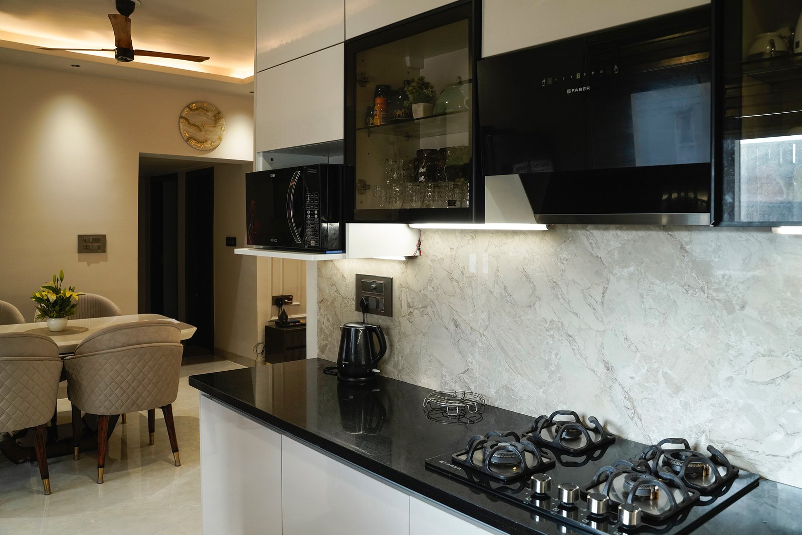 Modern L-Shaped Kitchen Design with Marble Backsplash and Glass Cabinets