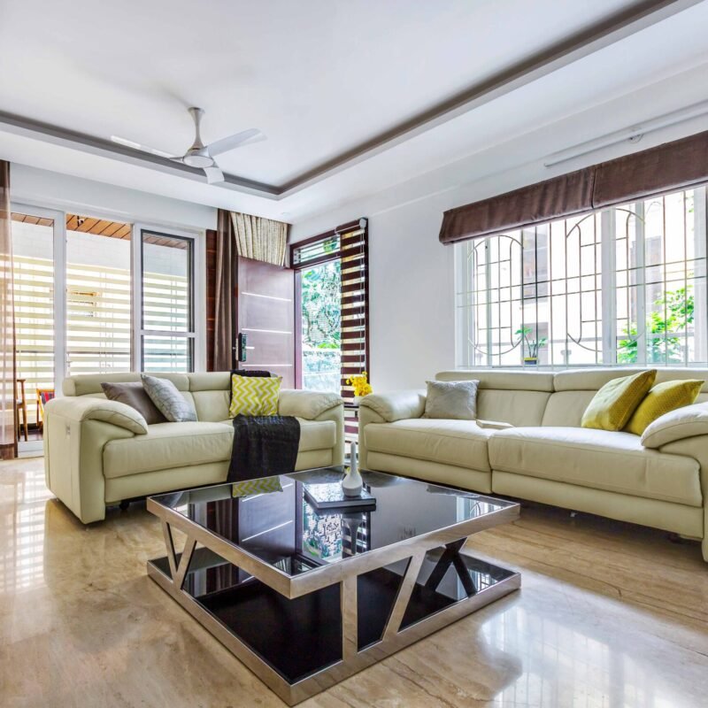 Contemporary Living Room Design With Cream Sofas and Black Glass Coffee Table